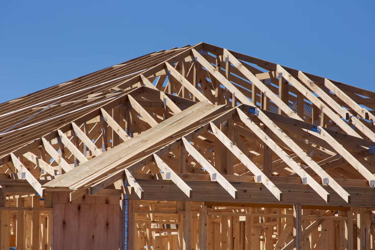 Charpente en bois d'une maison en construction sous un ciel dégagé
